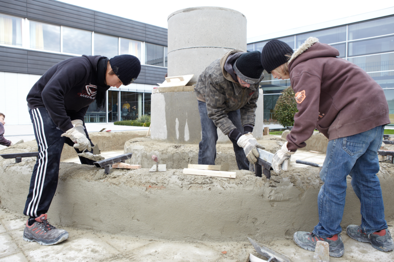 Schüler bauen auf dem Schulhof einen Brunnen
