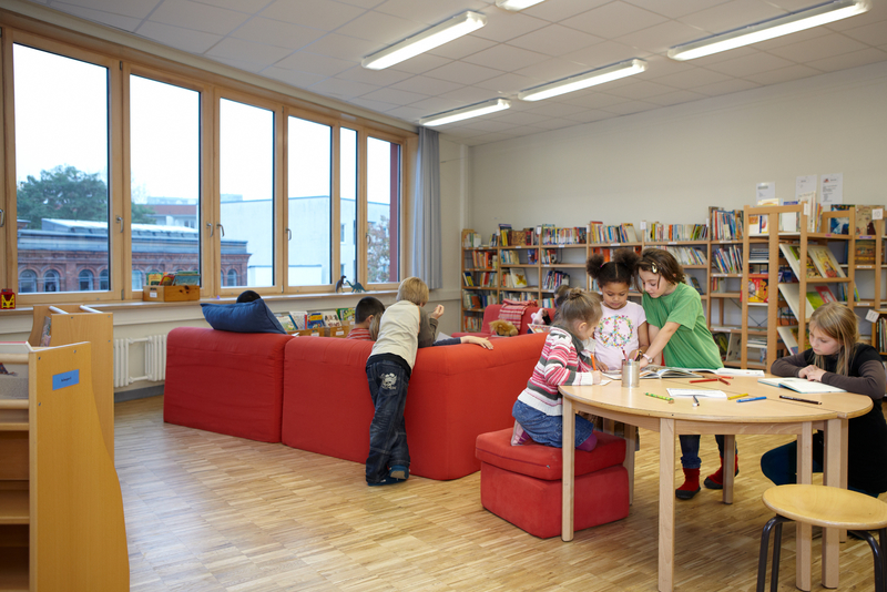 Schülerinnen und Schüler malen und spielen im Aufenthaltsraum