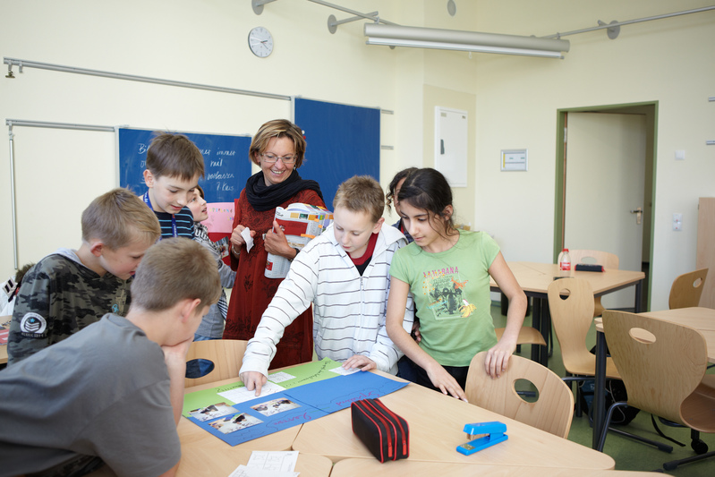 Schülerinnen, Schüler und eine Lehrerin im Klassenzimmer