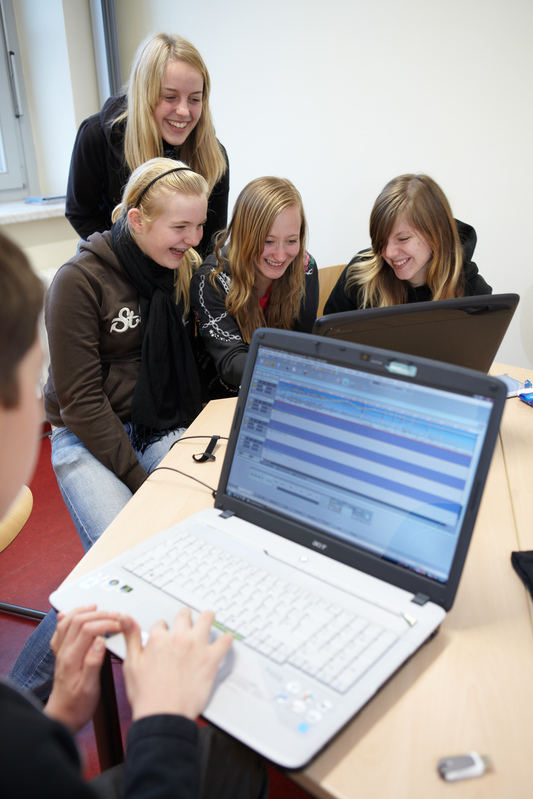 Schülerinnen und Schüler an Laptops