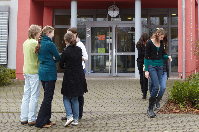 Schülerinnen und Schüler stehen vor dem Eingang