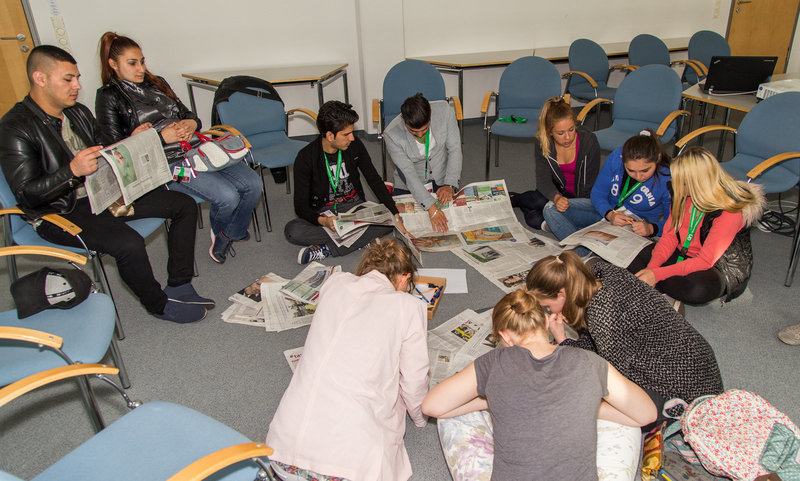 Schülerinnen und Schüler lesen Zeitung bei einem Workshop