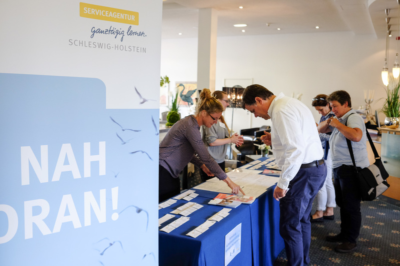 Besucher am Stand der Service-Agentur