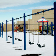 Aufnahme von Schaukeln auf einem Spielplatz im Winter.