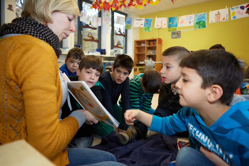 Lehrerin und Schüler betrachten ein Buch