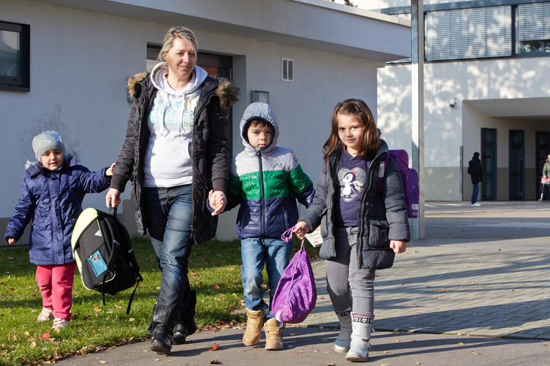 Mutter holt Kinder von der Schule ab