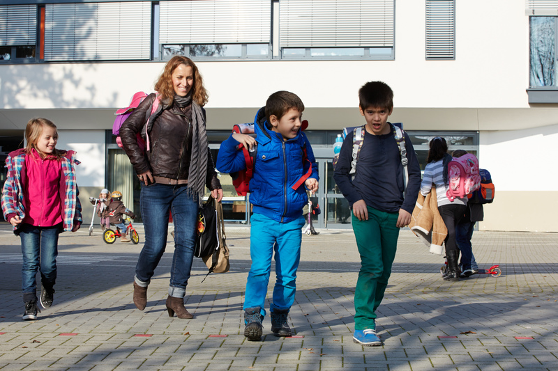 Mutter holt ihre Kinder von der Schule ab