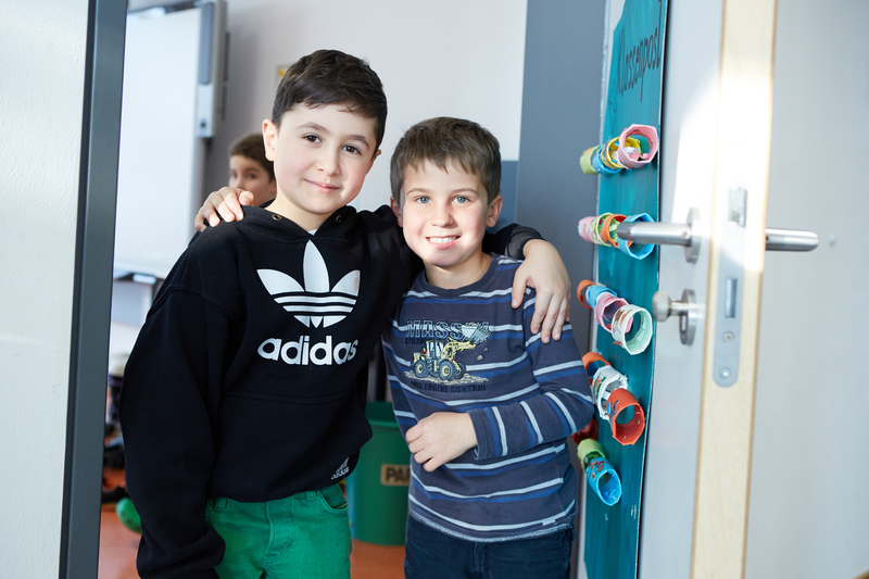 Zwei Schüler stehen Arm in Arm