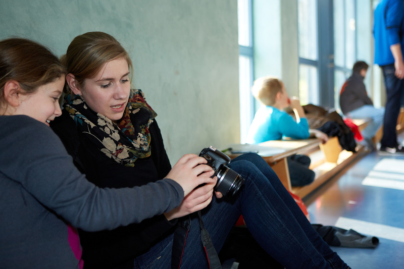 Lehrerin mit Schülerin und Fotoapparat