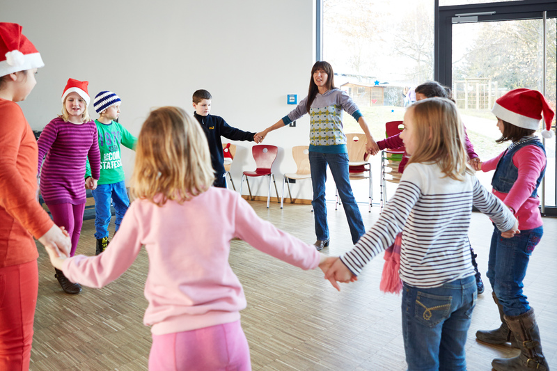 Kinder mit Niklausmützen tanzen im Kreis