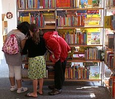 Drei Schülerinnen an einer Bücherwand