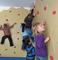 Kinder an einer Indoor-Kletterwand