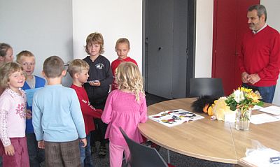 Schülerinnen und Schüler mit einem Lehrer in einem Zimmer