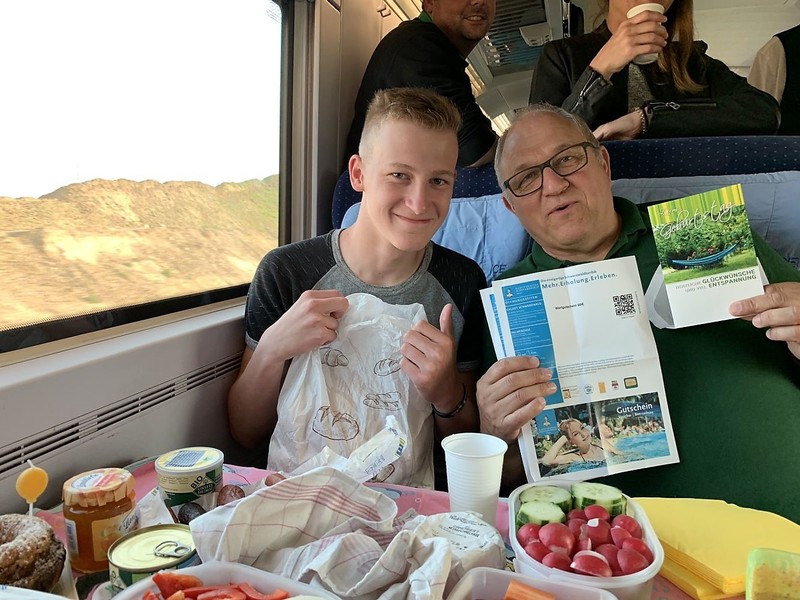 Schulleiter und Schüler beim Frühstück im Zug