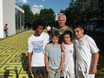 Gruppenfoto von vier Schülern mit einem Lehrer auf einem Hof