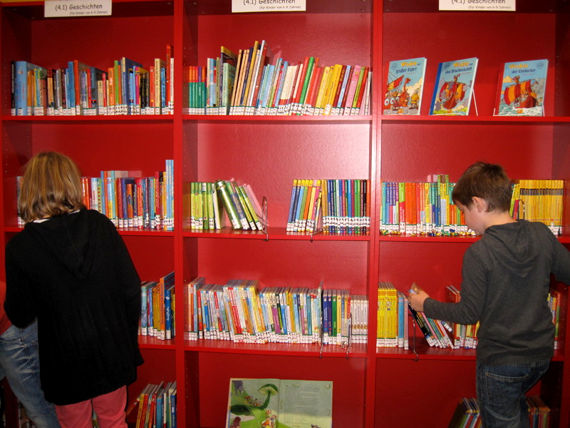 Schüler vor einem Bücherregal