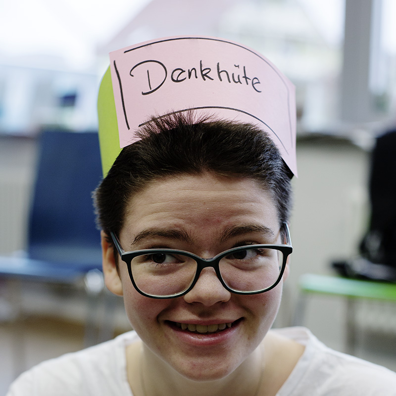 Schüler mit Hut mit der Aufschrift "Denkhut"