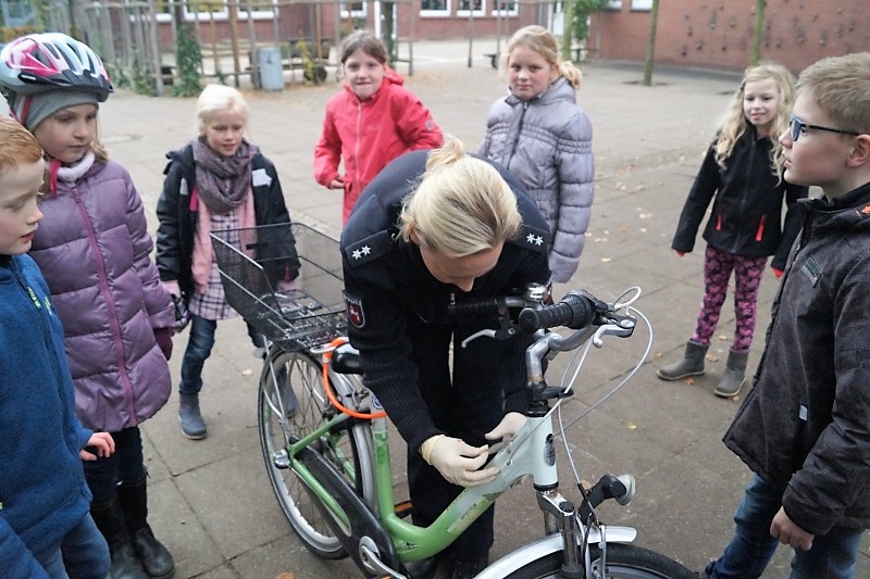 Polizistin und Schüler bei einer Fahrrad-Aktion