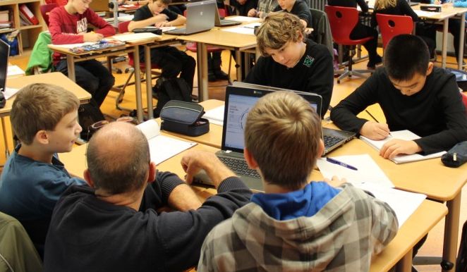 Schüler und Lehrer vor Notebooks
