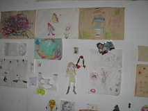 Blick auf eine Wand voller Kinderbilder