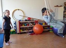 Zwei Kinder schaukeln an einem Seil