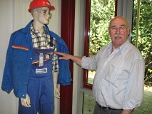 Ein Mann steht neben einer Schaufensterpuppe, die wie ein Handwerker gekleidet ist.