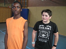 Zwei Jungen stehen in einer Sporthalle.