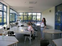 Schüler lernen in einem großen Raum mit Tischen