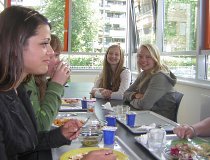 Jugendliche sitzen gemeinsam an einem Tisch und essen.