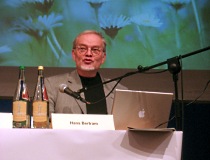 Ein Mann steht an einem Rednerpult und spricht in ein Mikrofon.