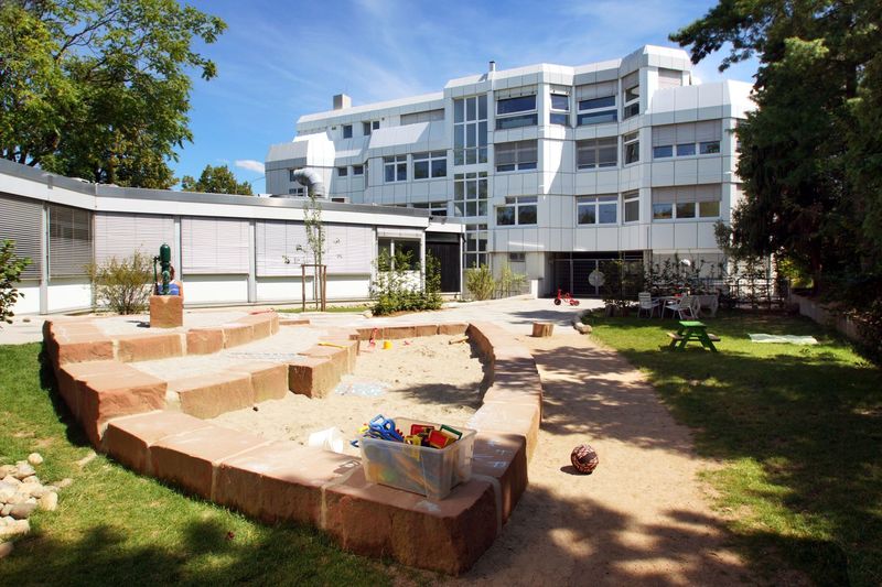 Sandkasten vor Schulgebäude