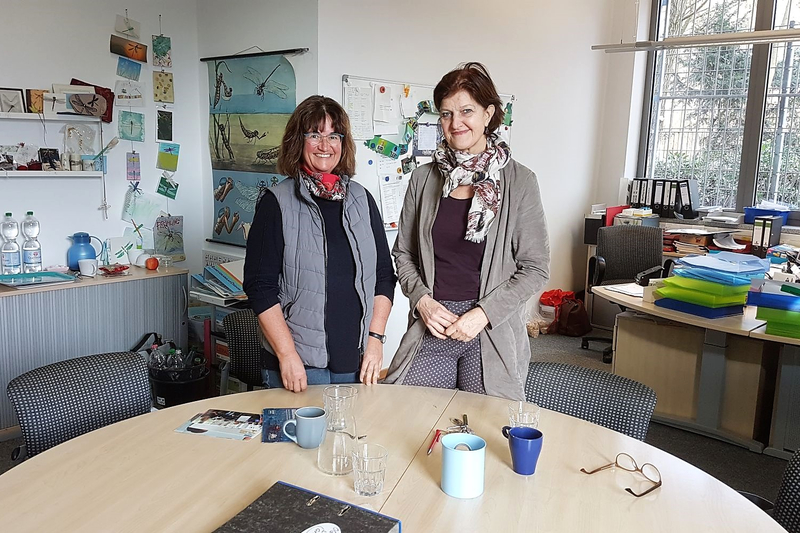 Angelika Strößner und Christiane Mika stehen in ihrem Büro