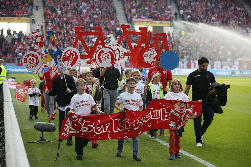 Mannschaft und Kids Club drehen eine Stadionrunde