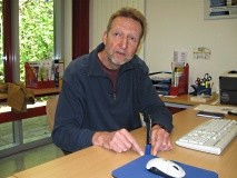 Ein Mann sitzt an einem Schreibtisch.