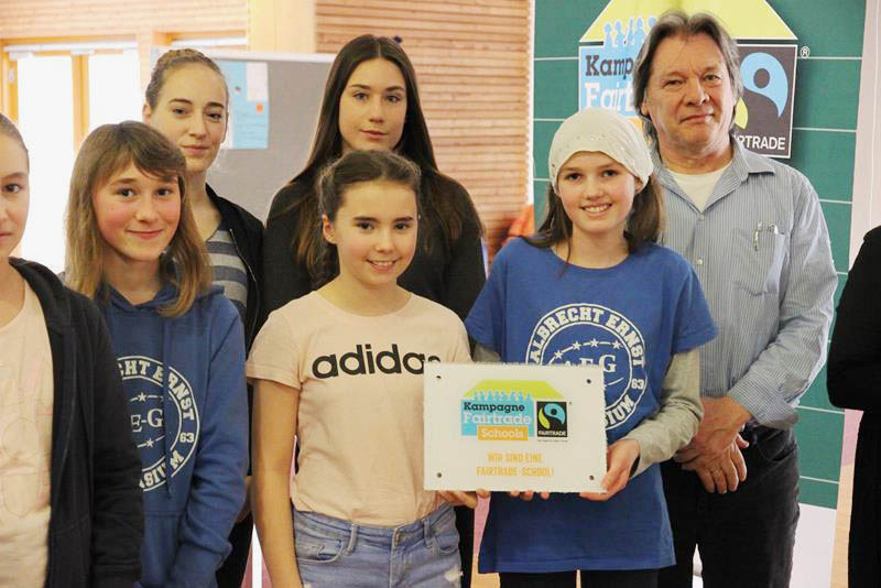 Gruppenfoto von Schülerinnen und Schülern mit Schulleiter Schmalisch und dem Fairtrade-Siegel
