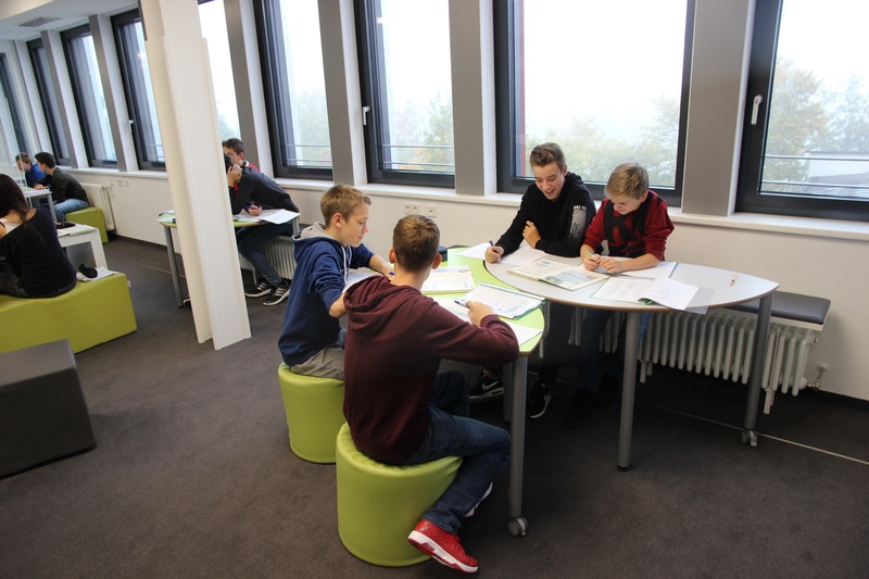 Schüler sitzen als Lerngruppe zusammen