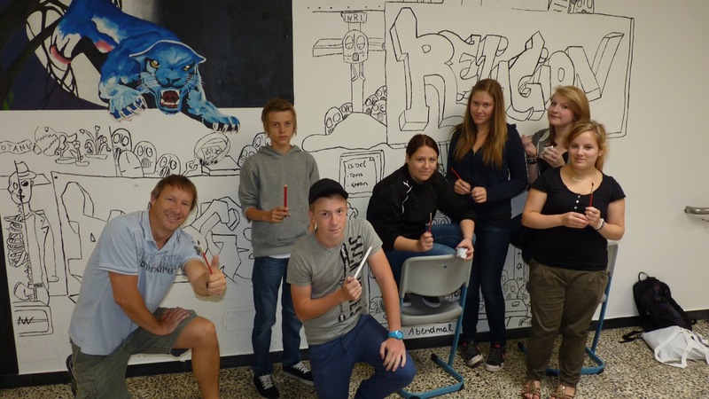 Lehrer, Schülerinnen bei der Gestaltung eines Schulflurs