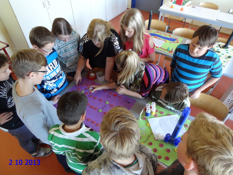 Schülerinnen und Schüler bei einem selbst gebastelten Brettspiel