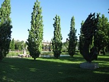 Aufnahme einer Parklandschaft mit einer Schlossanlage im Hintergrund.