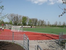 Blick auf einen Sportplatz mit Rennbahn und Fußballtor.