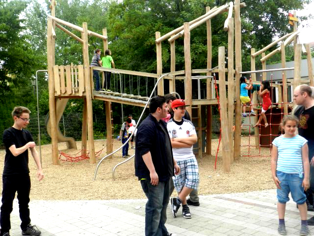 Schülerinnen und Schüler auf dem Schulhof, im Hintergrund ein Klettergerüst