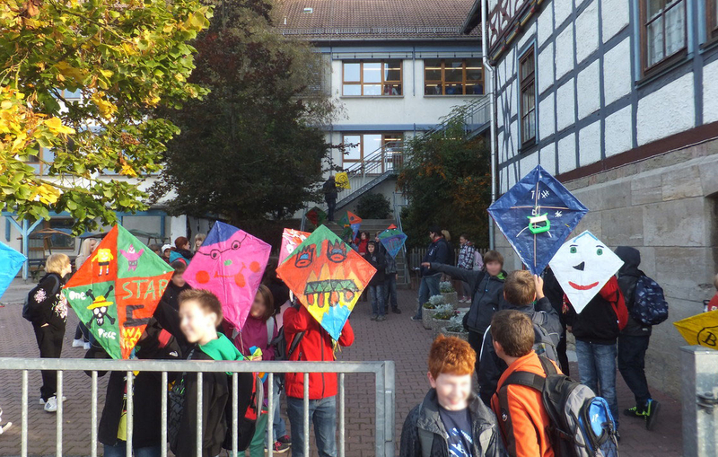 Schülerinnen und Schüler mit Drachen auf dem Schulhof