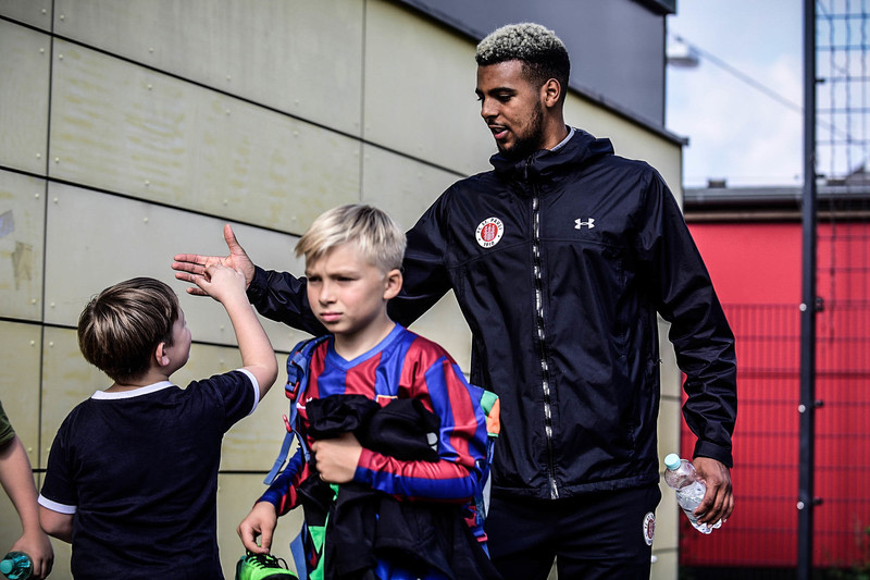Trainer mit Fußballerinnen und Fußballern
