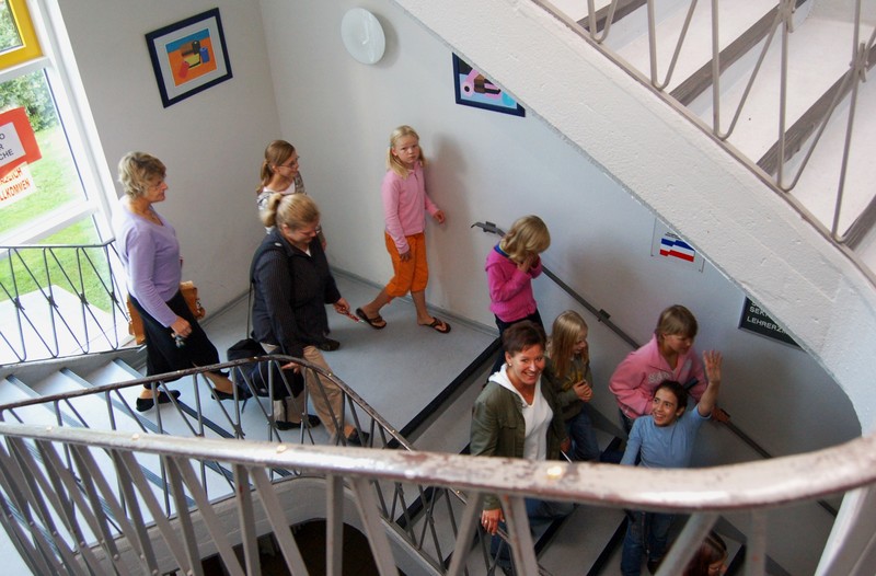 SchülerInnen und Lehrerinnen im Treppenhaus der Schule
