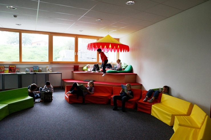 Kinder in einem Ruhezimmer mit Sitz- und Liegemöglichkeiten